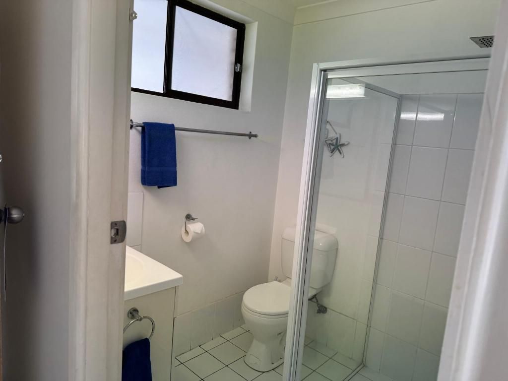A bathroom with a toilet, a sink, and a shower enclosure.