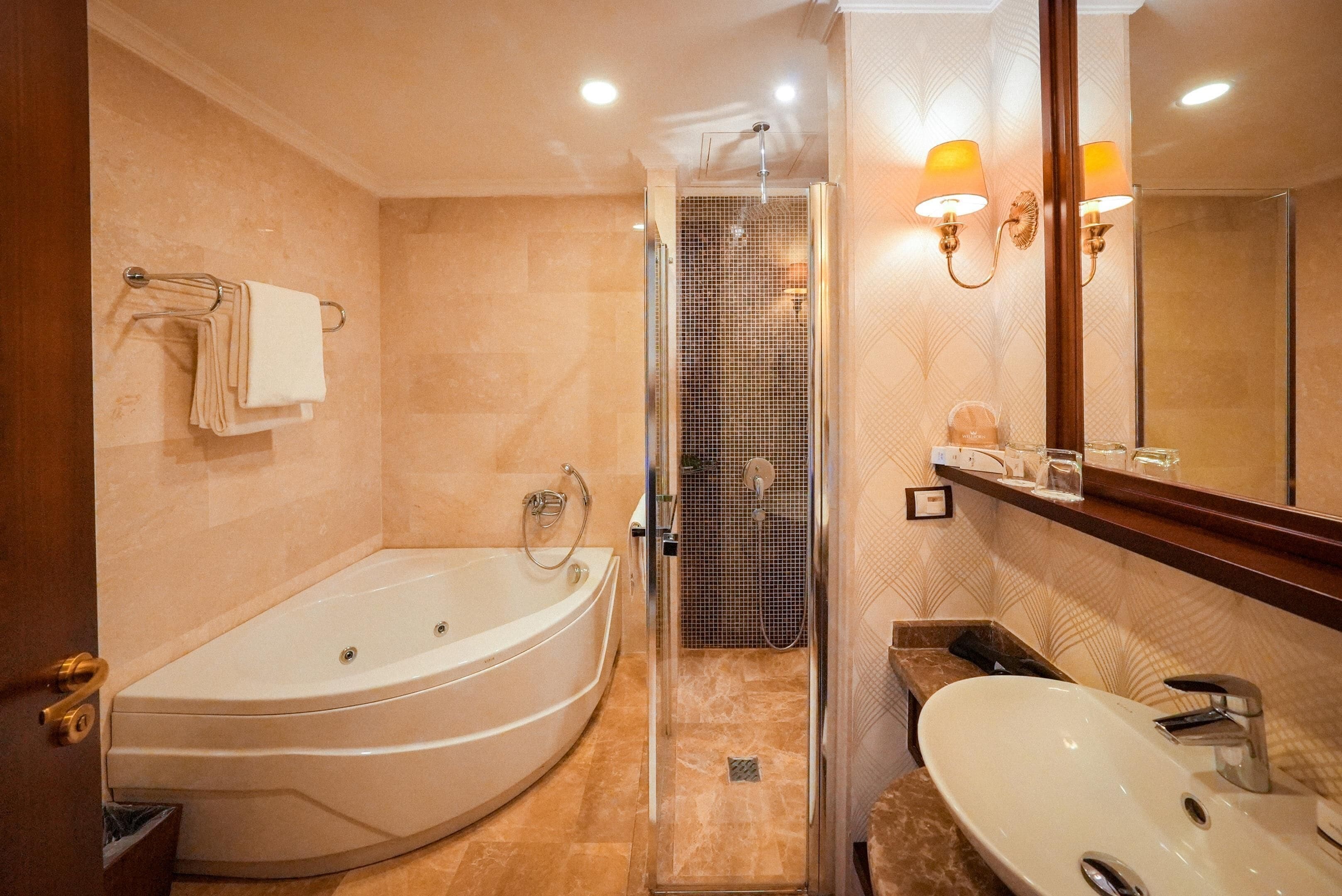 A modern bathroom with a large bathtub, a walk-in shower, and a vanity with a mirror.