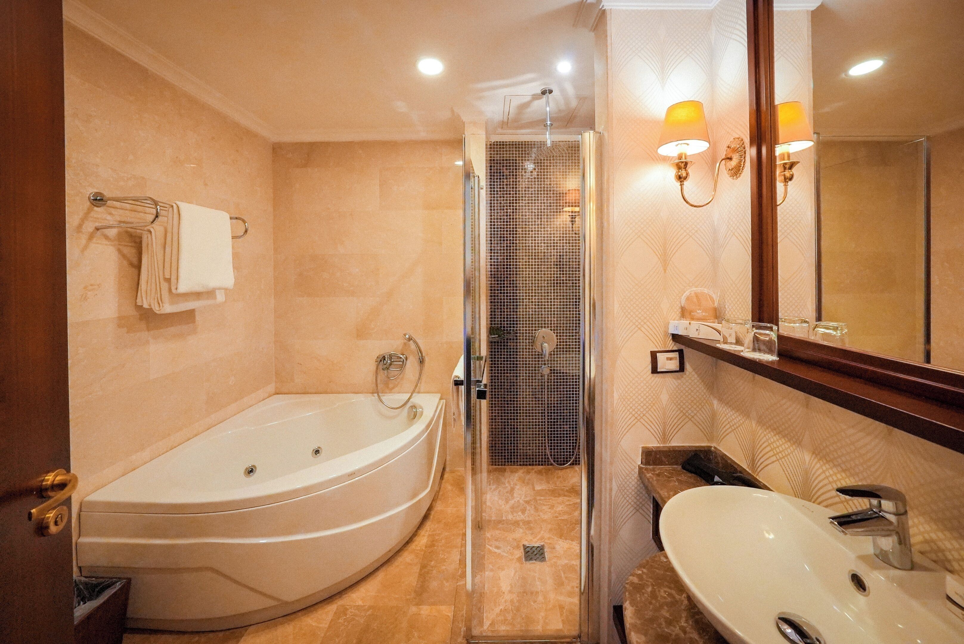 Une salle de bain avec une baignoire, une douche, un lavabo et un miroir.