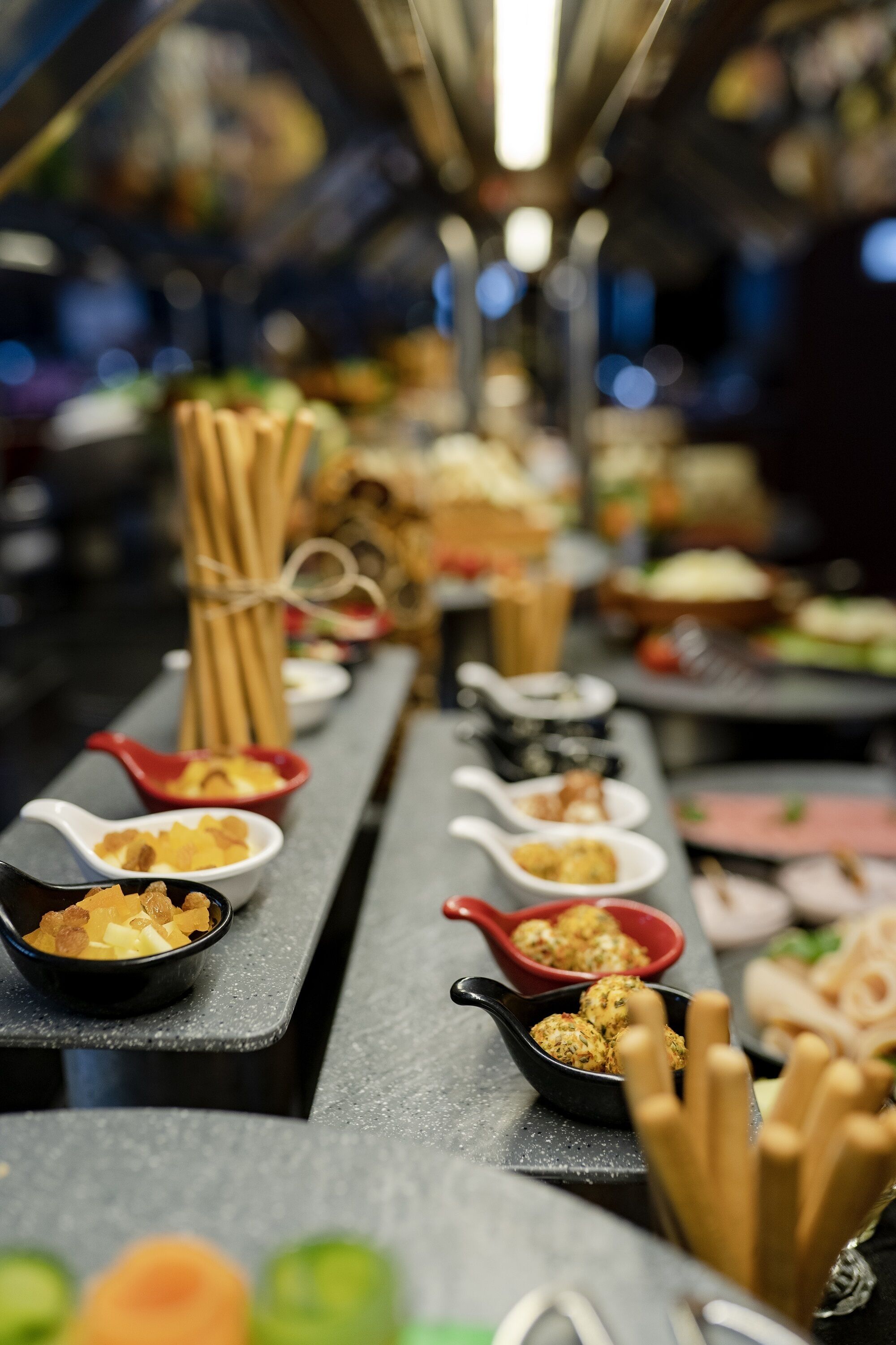 A buffet table with various dishes and utensils.