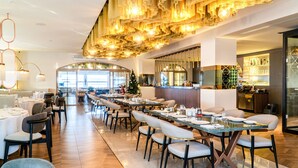 A spacious dining area with long tables, chairs, and a modern ceiling design. - Wellborn Luxury Hotel (Basiskele)