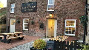 Un edificio de ladrillo con un letrero que dice "The Blue Bell Inn Free House".