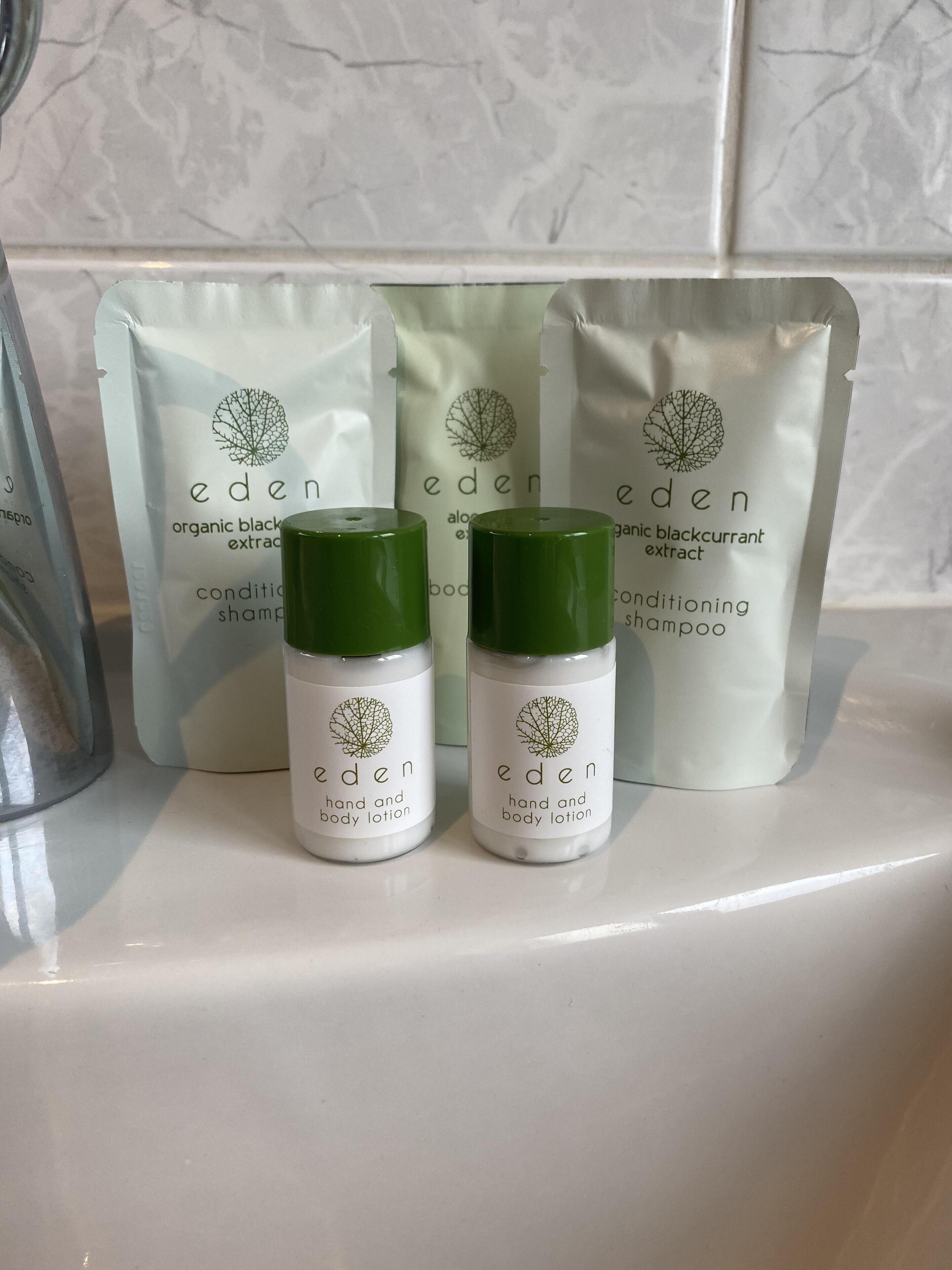 Dos botellas de crema corporal y de manos Eden, y tres bolsas de champú Eden con extracto orgánico de grosella negra.