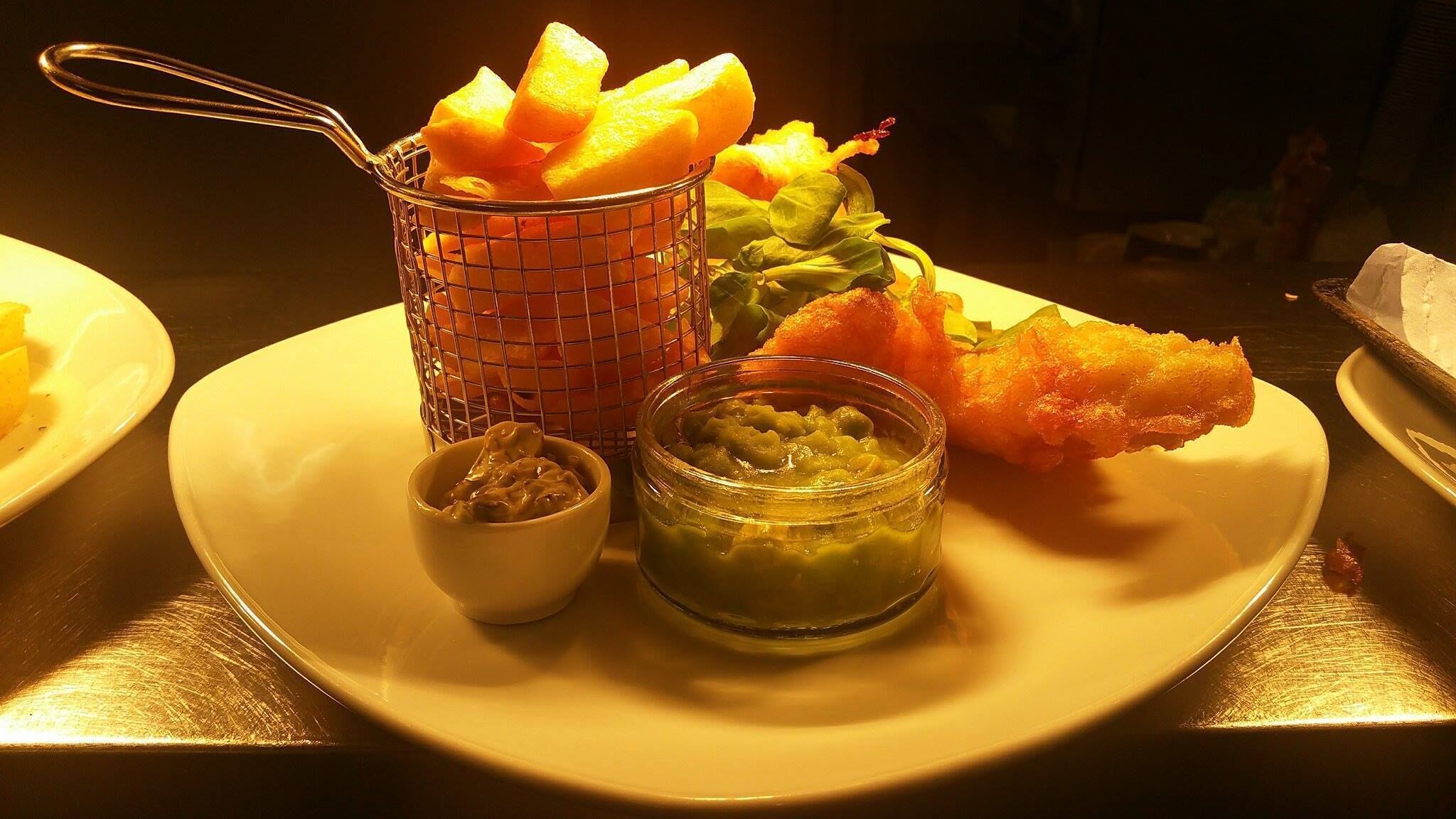 Ein Teller mit Tempura, eine kleine Schale mit Dipsoße und eine Schale eingelegtes Gemüse.