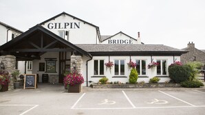 A building with a sign reading "GILPIN BRIDGE" and a parking area with bicycle symbols. - Gilpin Bridge Inn (Kendal)