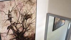 A staircase with a modern design, a large abstract painting on the wall, and a mirror reflecting the staircase. - Hostal Valdepeñas by Bossh Hotels (Valdepenas)