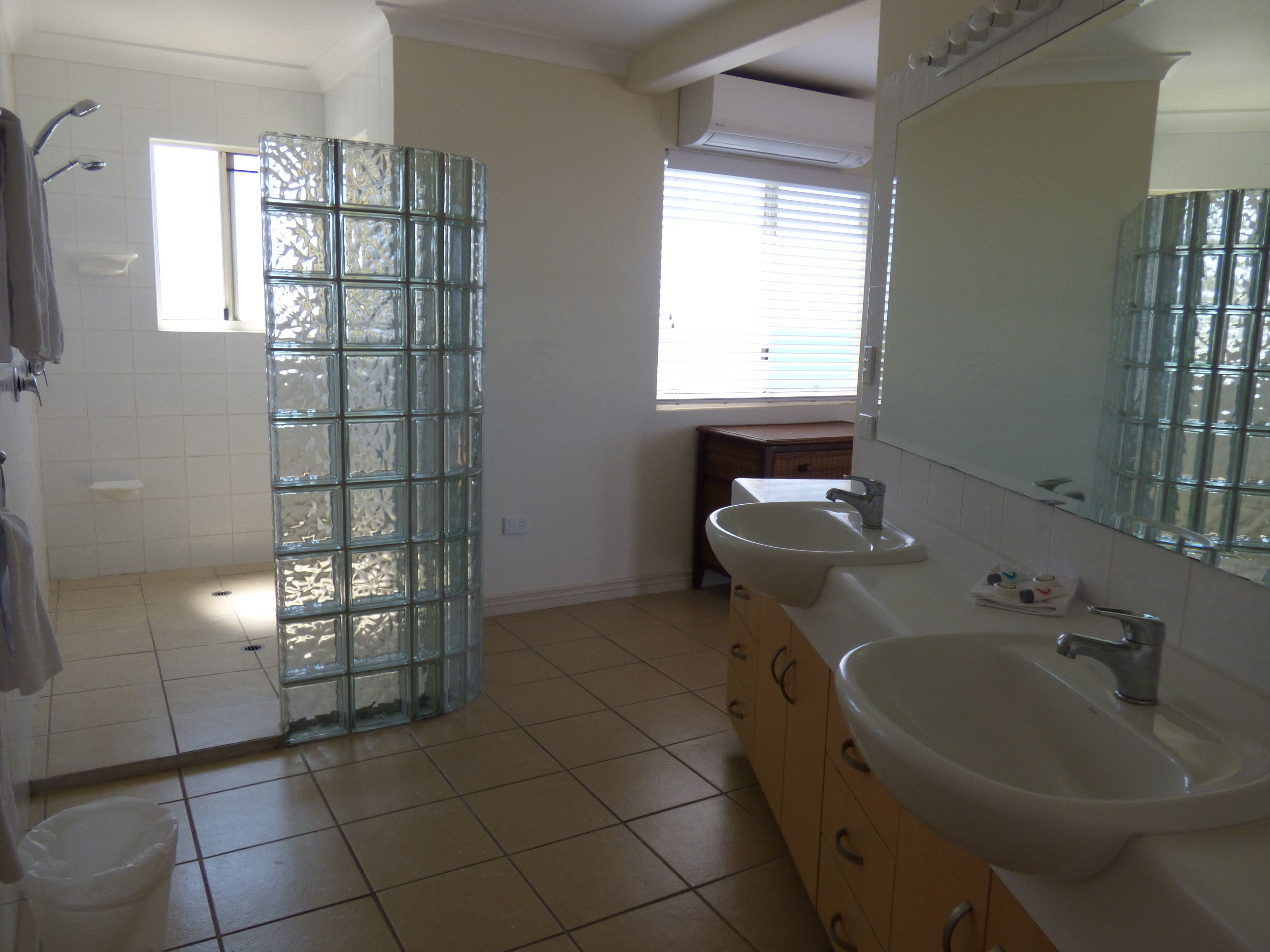 A bathroom with a glass shower enclosure, a sink, and a vanity.