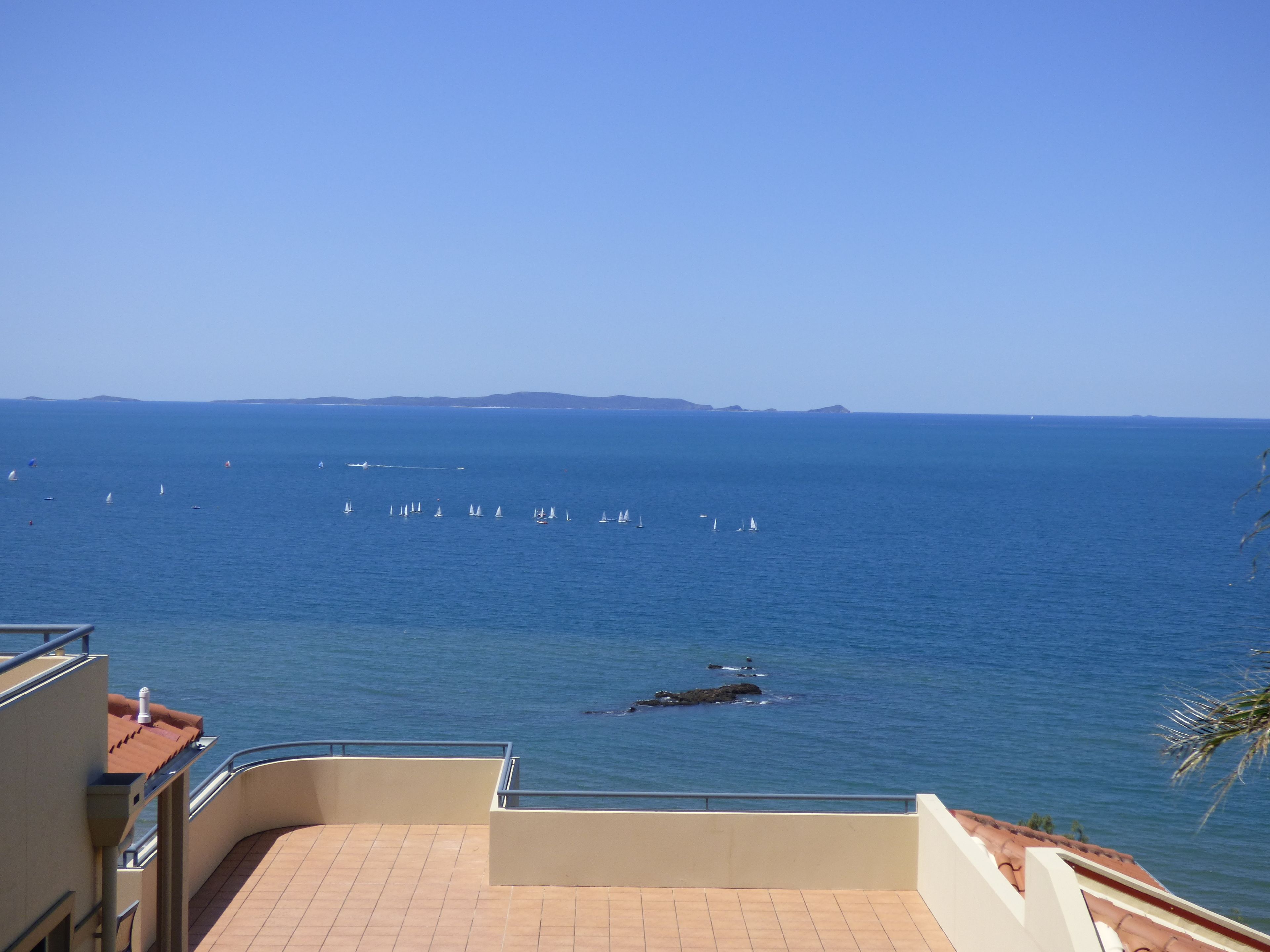 Un balcón con vista al mar y a veleros.