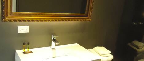 A bathroom with a white vanity, a mirror, and a toilet.