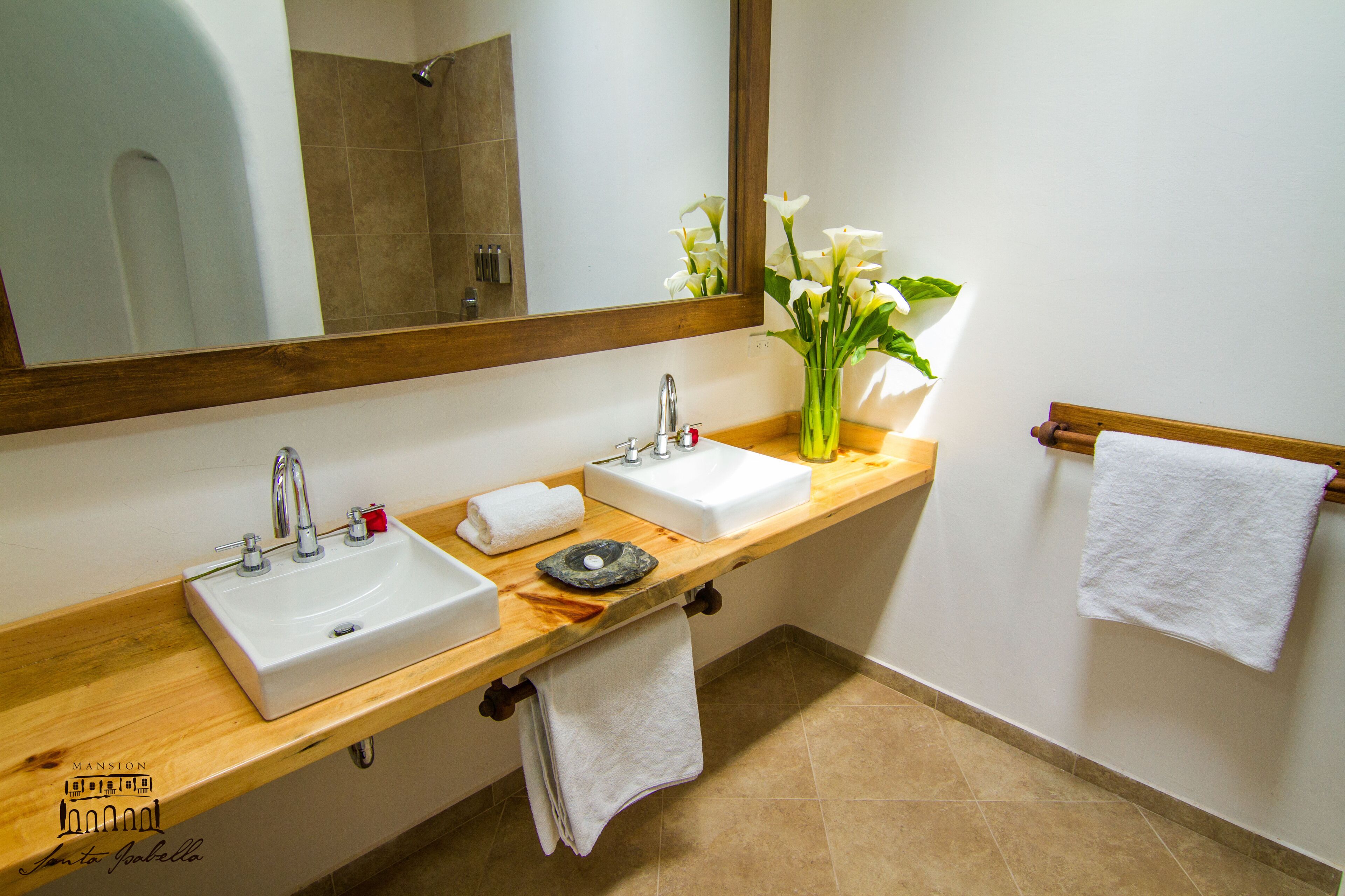 Un baño con dos lavamanos, un espejo y una encimera de madera.