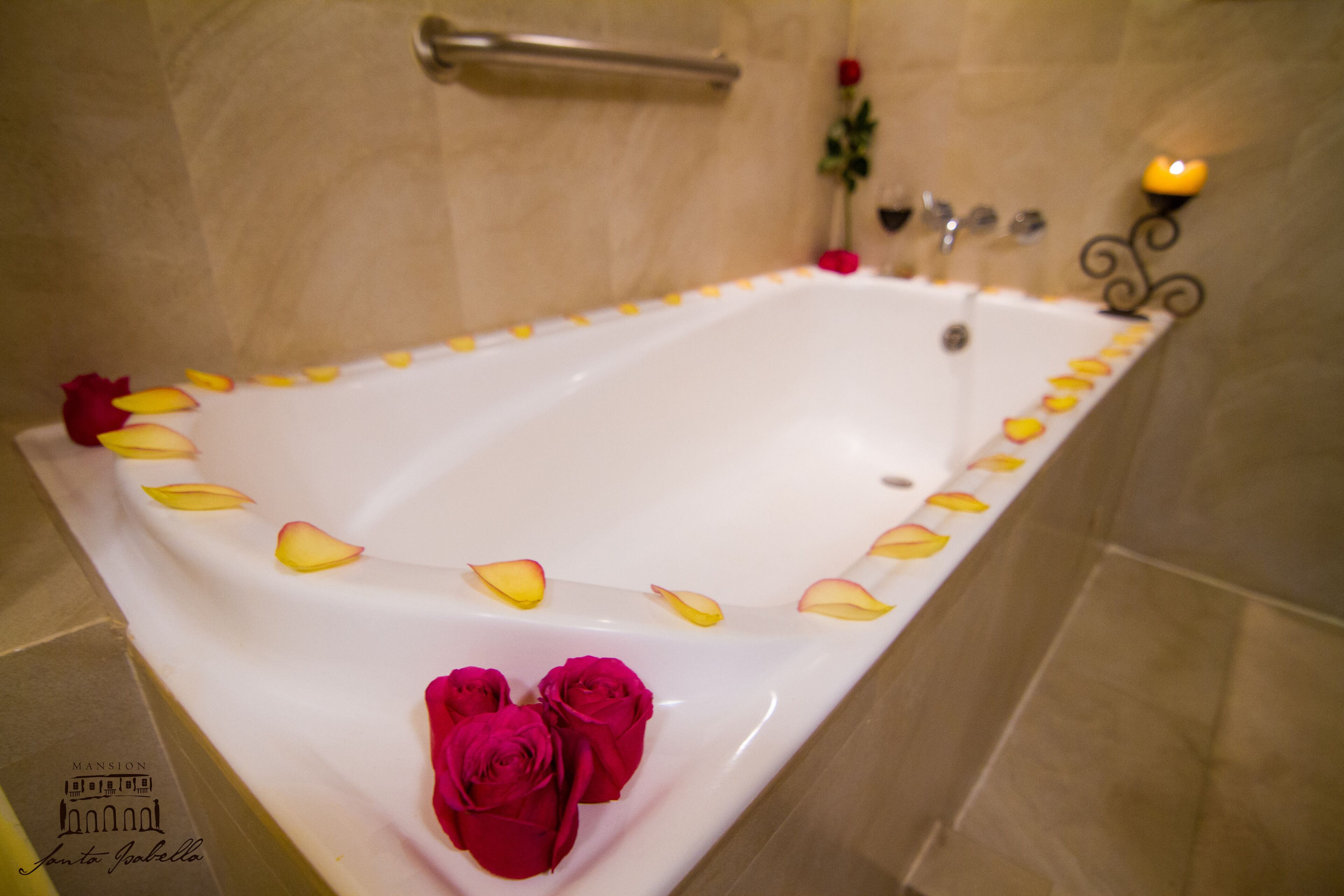 A bathtub with rose petals and roses.