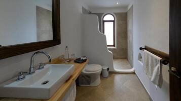 Un baño moderno con lavamanos, inodoro y ducha.