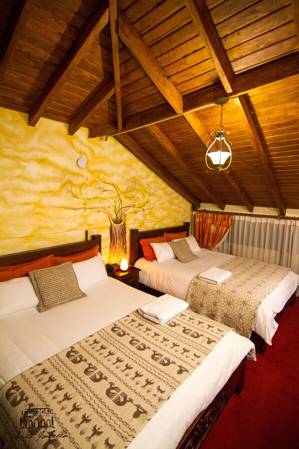A room with two beds, wooden beams on the ceiling, a decorative wall, and a hanging light fixture.