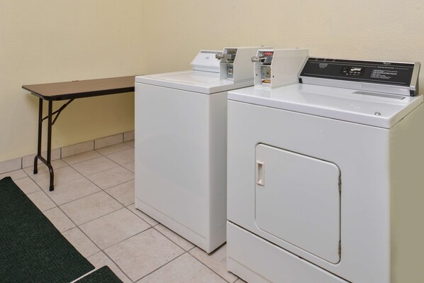 A laundry area with two white washing machines and a small table. - Americas Best Value Inn Houston at FM 1960 & I-45 (Houston)