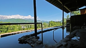 A pool with a view of mountains and greenery. - Hakuba Highland Hotel (Hakuba)