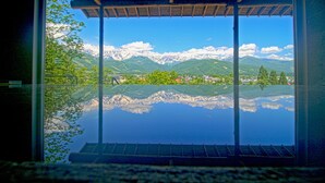 A view through a glass window of a mountain landscape with snow-capped peaks and a clear sky. - Hakuba Highland Hotel (Hakuba)
