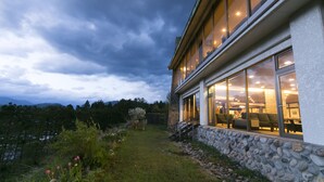 A modern building with large windows, a stone foundation, and a view of the surrounding landscape. - Hakuba Highland Hotel (Hakuba)