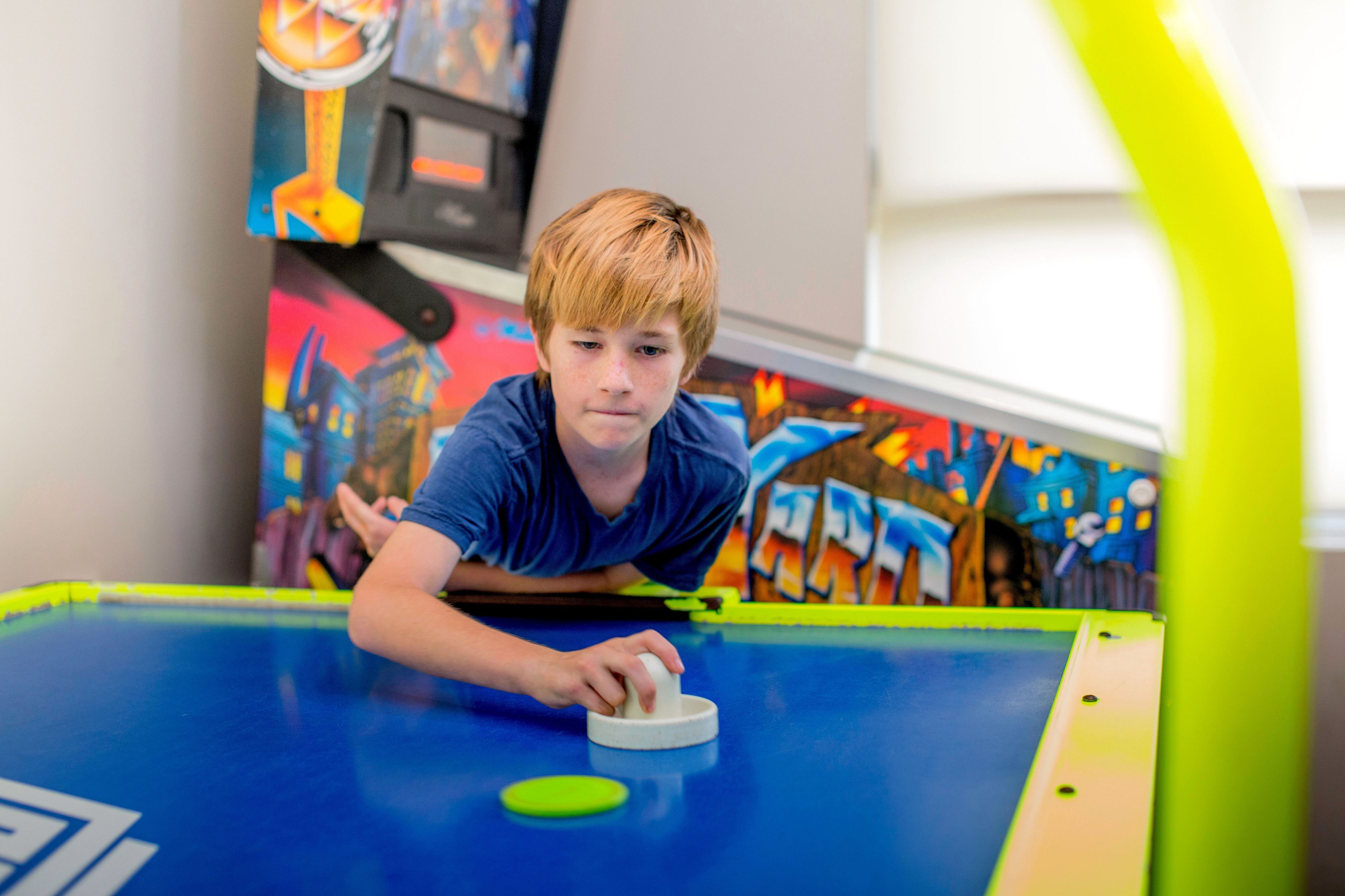 A person playing pool in a room with colorful graffiti on the walls.