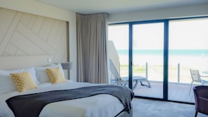Una habitación de hotel con cama, una silla y vista a la playa.