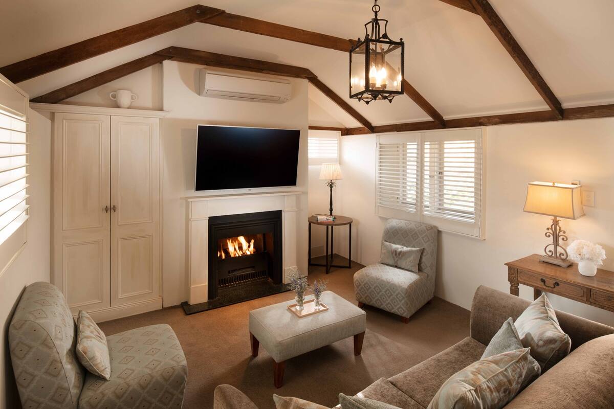 A cozy living room with a fireplace, a television, and comfortable seating.