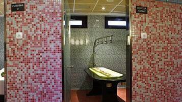 Un baño con paredes de mosaico, una bañera, un lavabo y una zona de ducha.