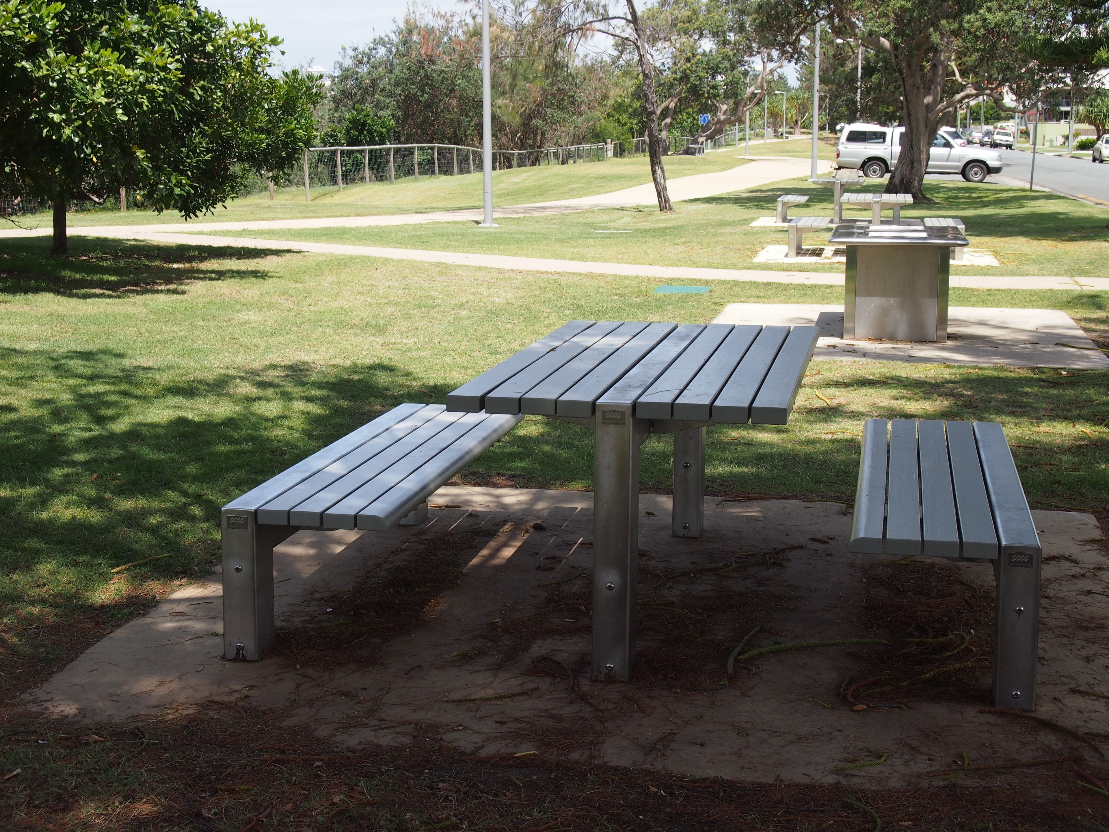 A park with picnic tables and benches.