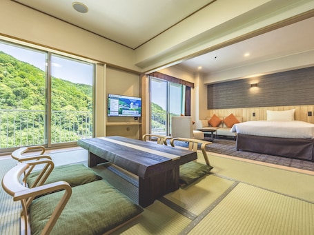 A hotel room with a bed, a desk, a chair, a sofa, and a television.. Yumoto Fujiya Hotel