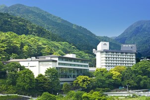 Un hotel de diseño moderno, rodeado de exuberante vegetación y montañas.