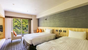 A hotel room with two beds, a large window with a view of greenery, a flat-screen TV, and a wooden headboard.