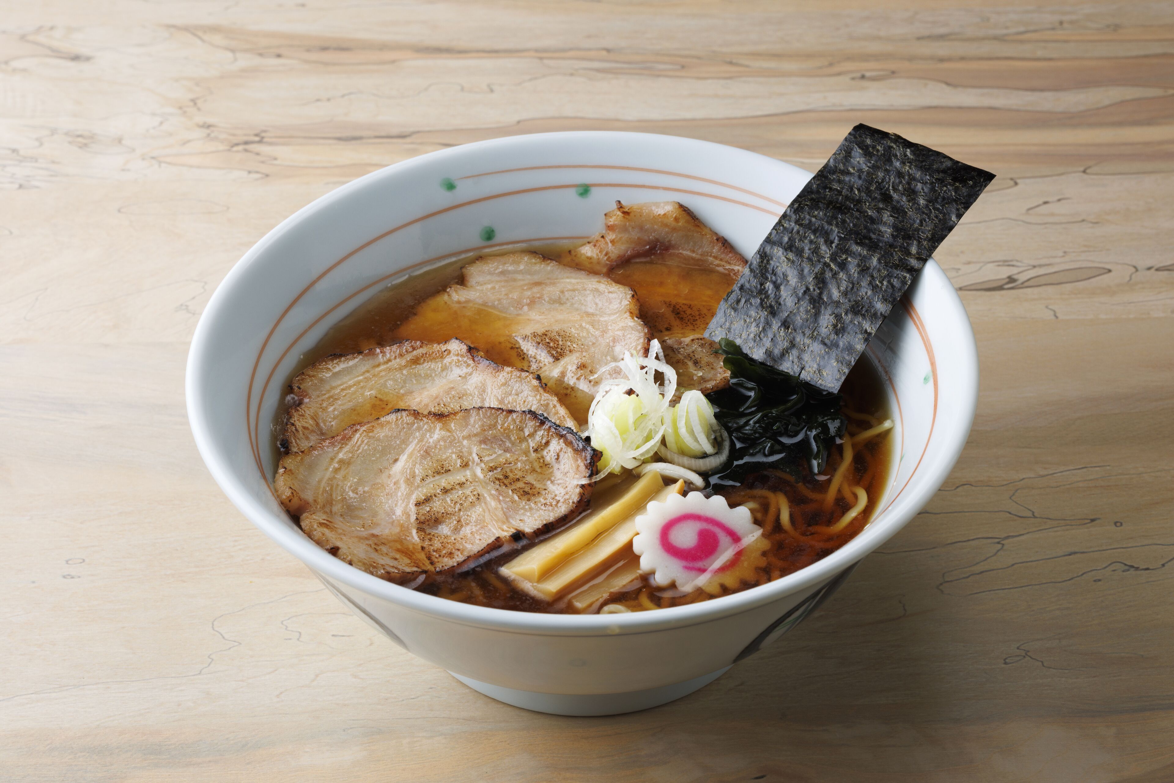 Un bol de ramen garni de divers ingrédients.