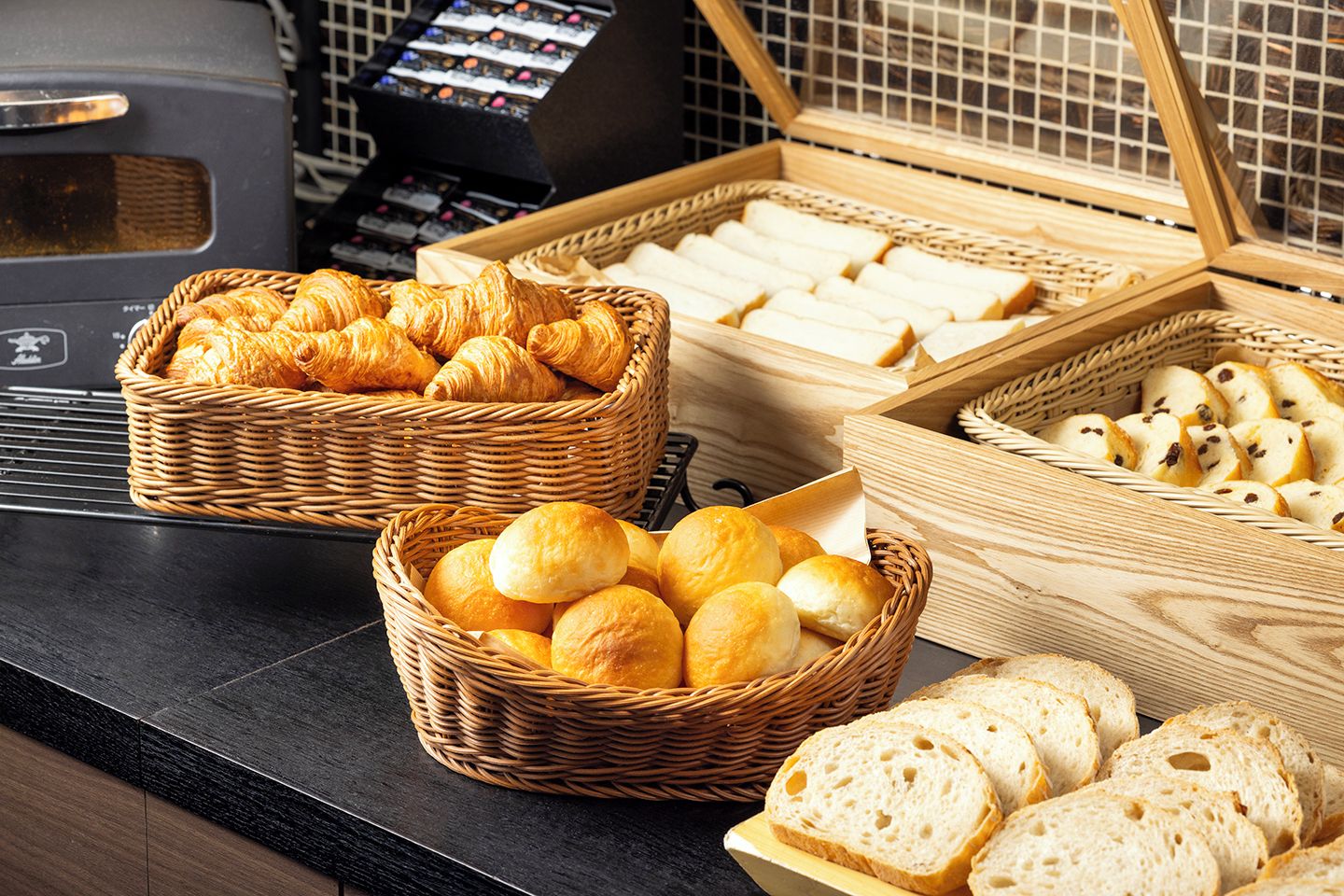 Diverse soorten brood en gebak gepresenteerd in rieten manden op een toonbank.