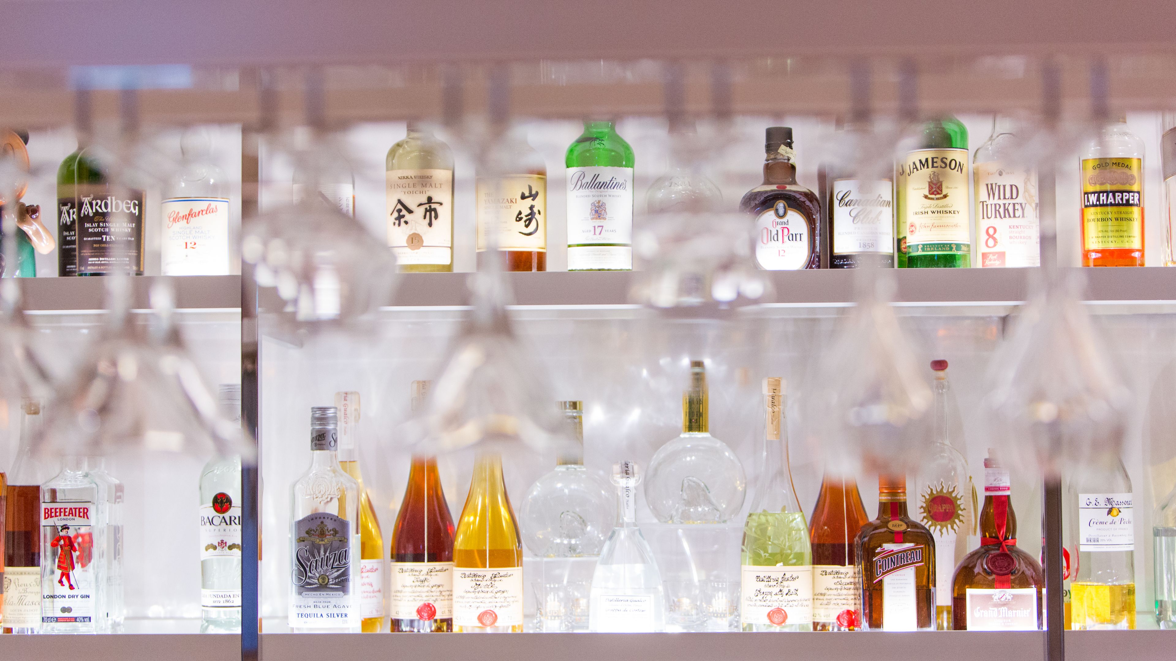 A variety of liquor bottles displayed on shelves.