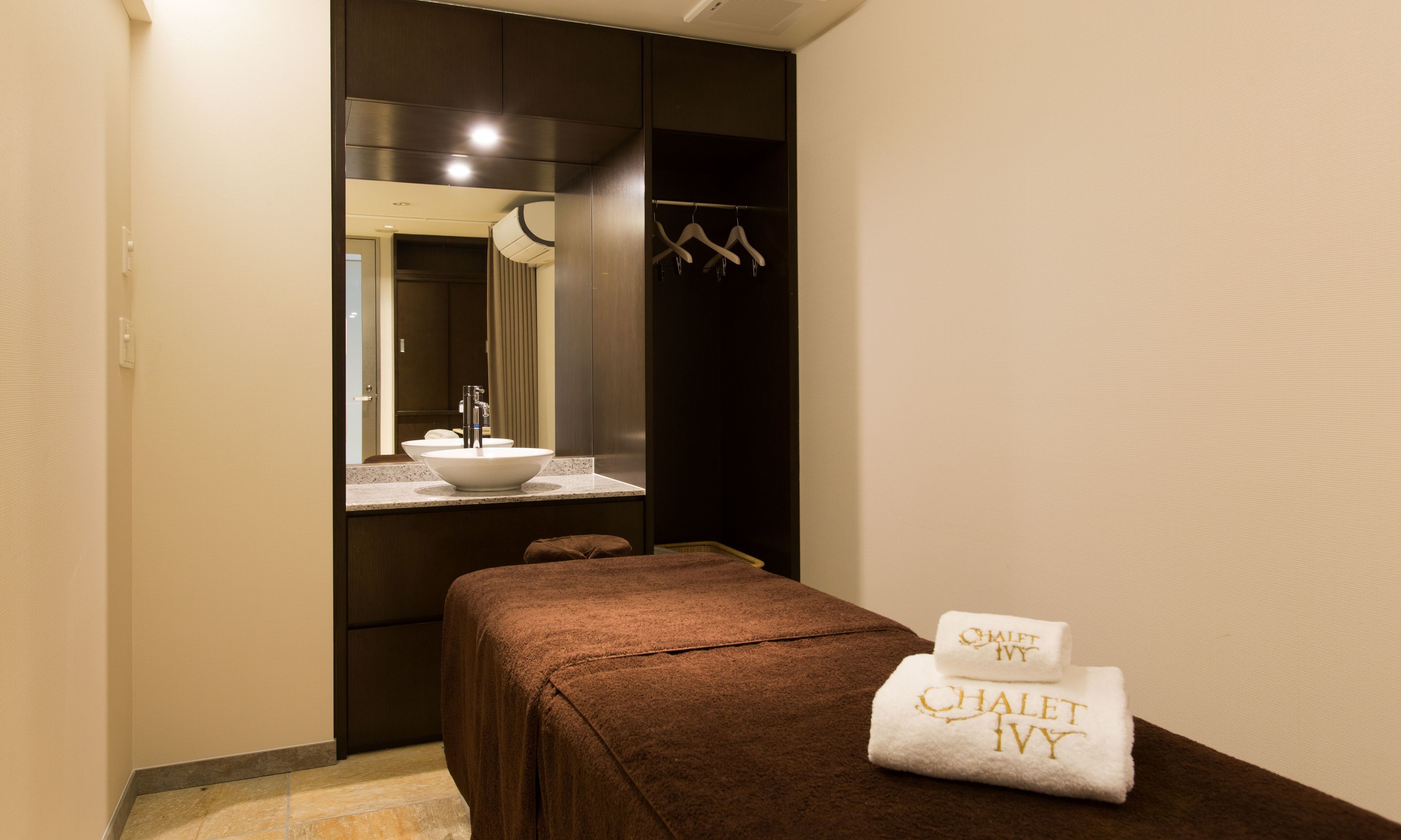 A modern bathroom with a large mirror, a sink, and a towel rack.