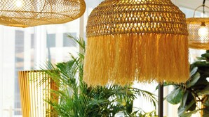 A cozy seating area with a round table, chairs, and a hanging light fixture.