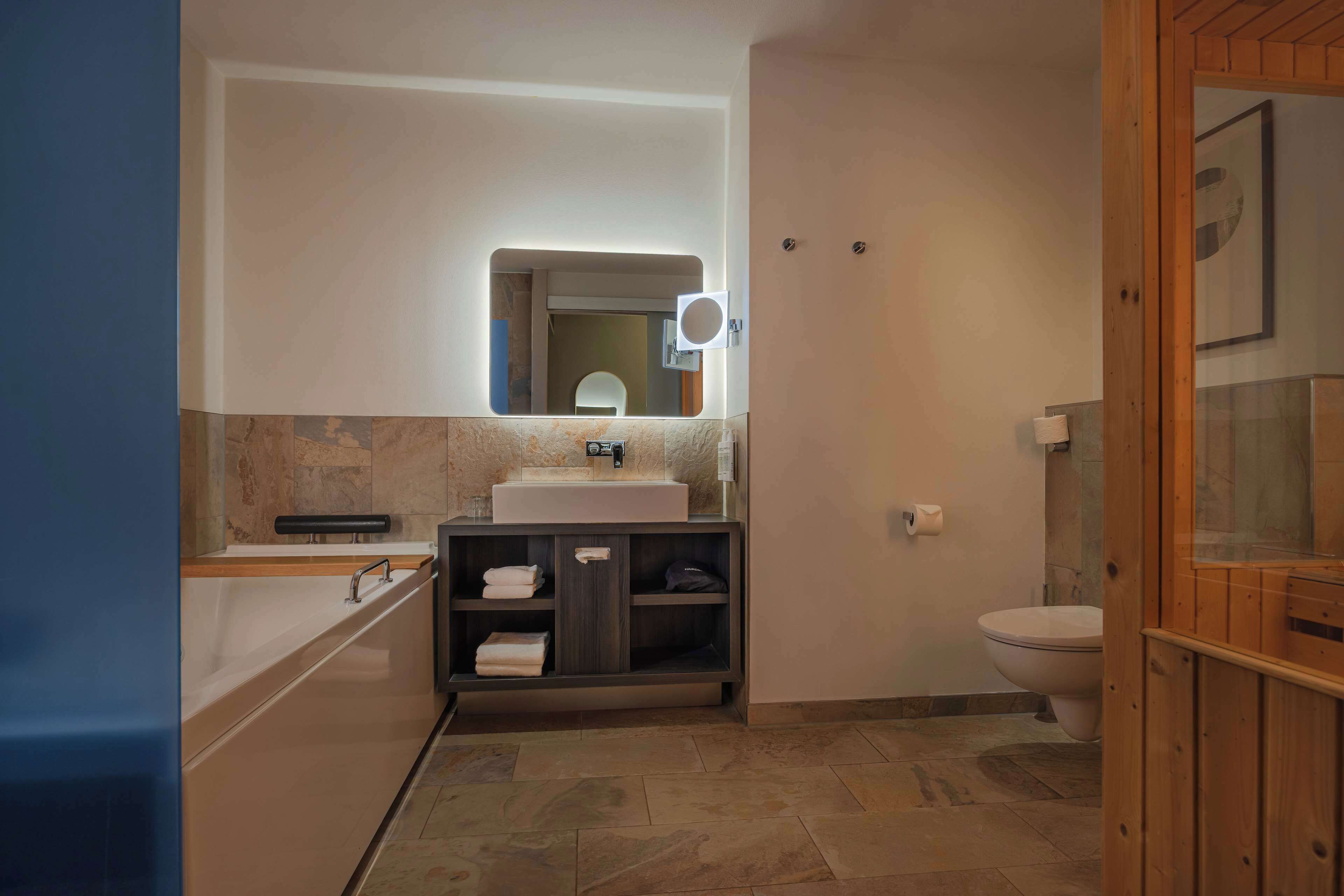 A modern bathroom with a bathtub, sink, and toilet.