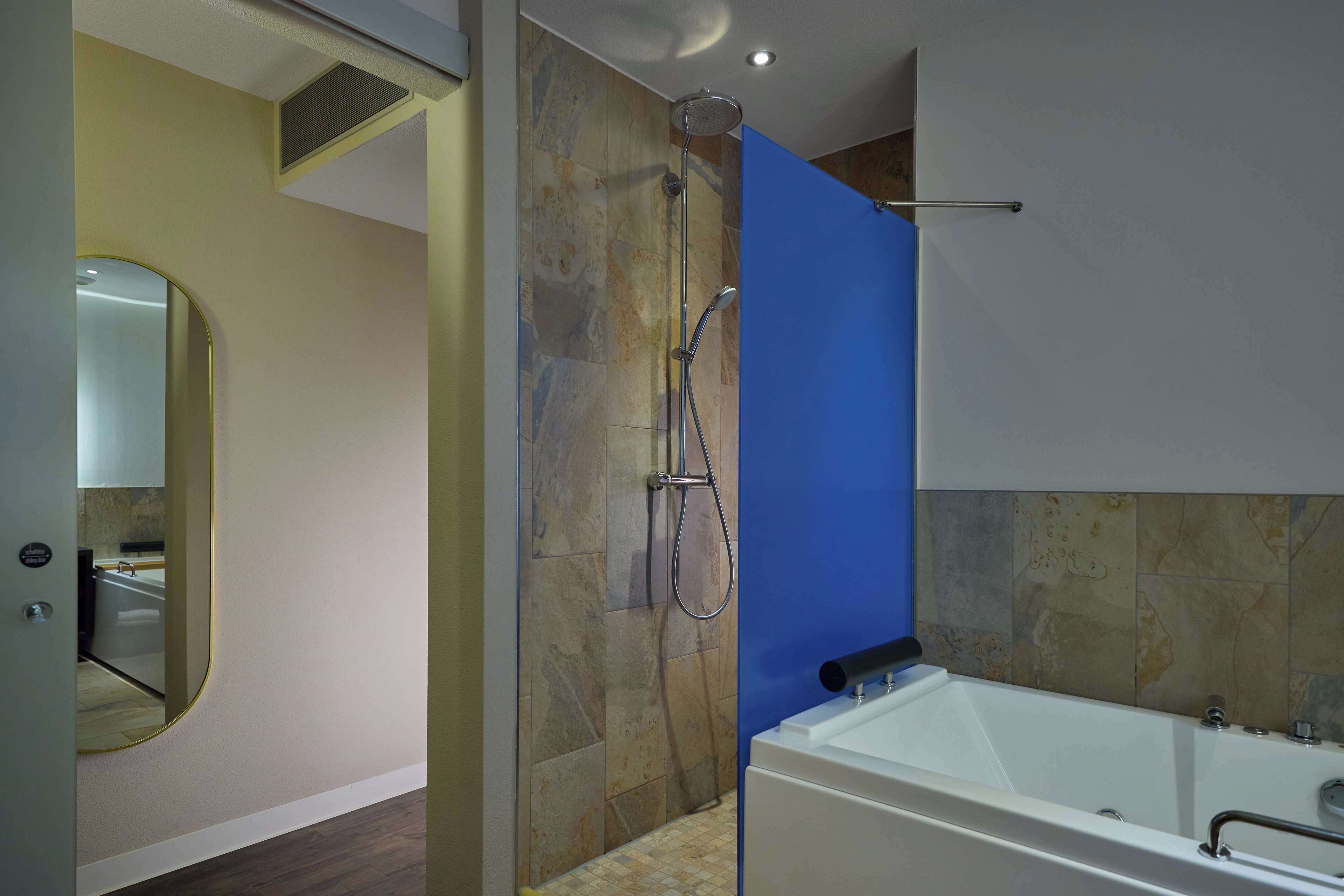 Un baño moderno con ducha, bañera y espejo.