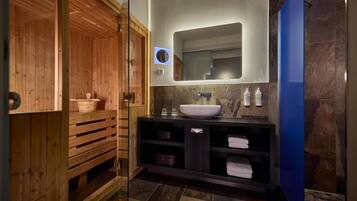 Un baño moderno con sauna de madera, un lavamanos grande con encimera de mármol y una pared decorada en azul.