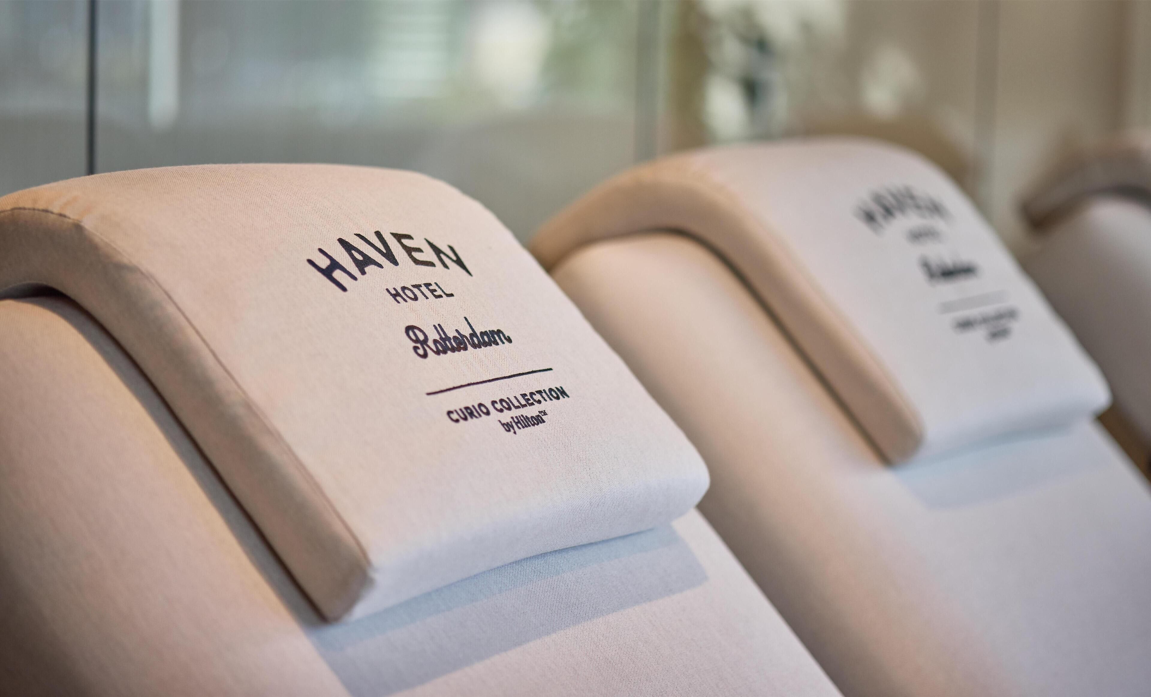 Primer plano de una almohada del Haven Hotel con el texto "Haven Hotel, Potassium, Curio Collection by Hilton".