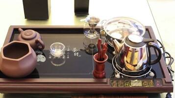 A tray with a teapot, cups, and a glass on a table.