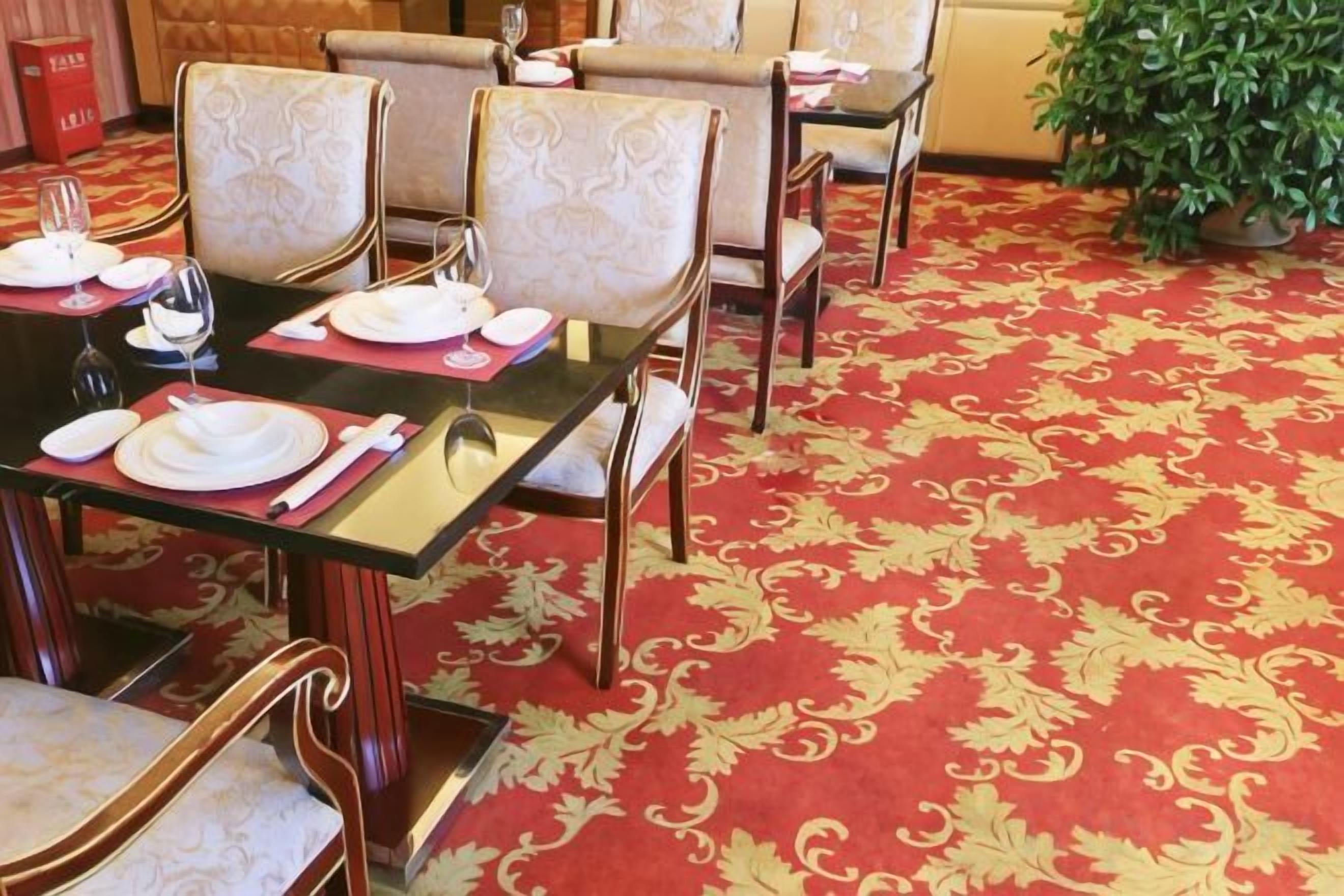 A dining area with tables set for four, each with chairs and tableware.