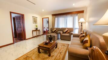 A spacious living room with a sofa set, a coffee table, and a decorative rug.