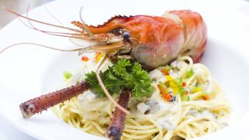 Un plato de pasta y un langostino cocido.