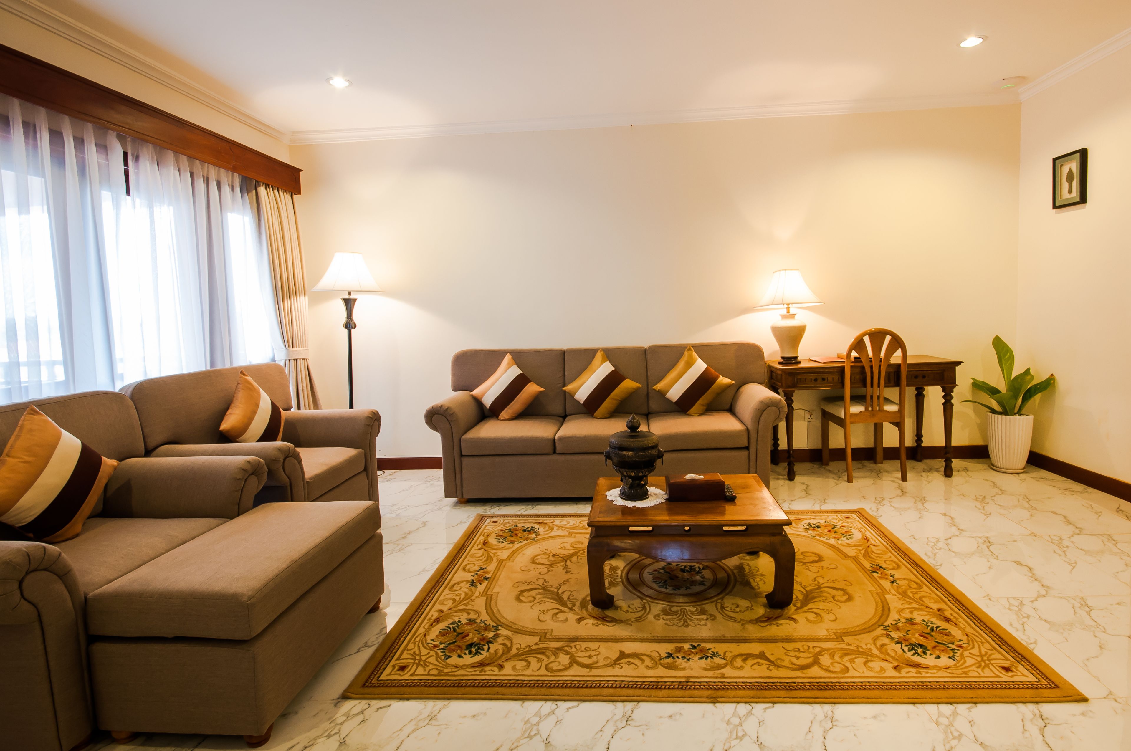 A living room with a sofa, armchair, coffee table, and lamps.