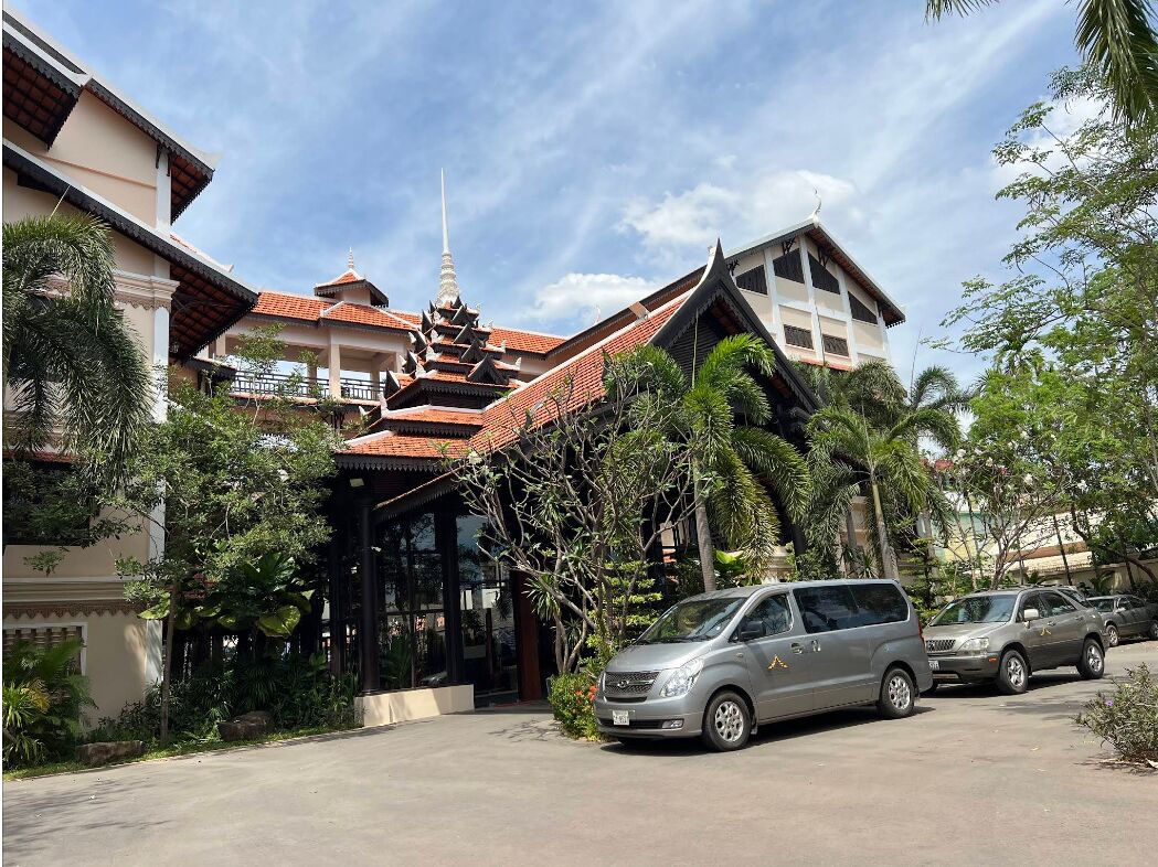 A traditional building with a multi-tiered roof and a modern car parked in front.