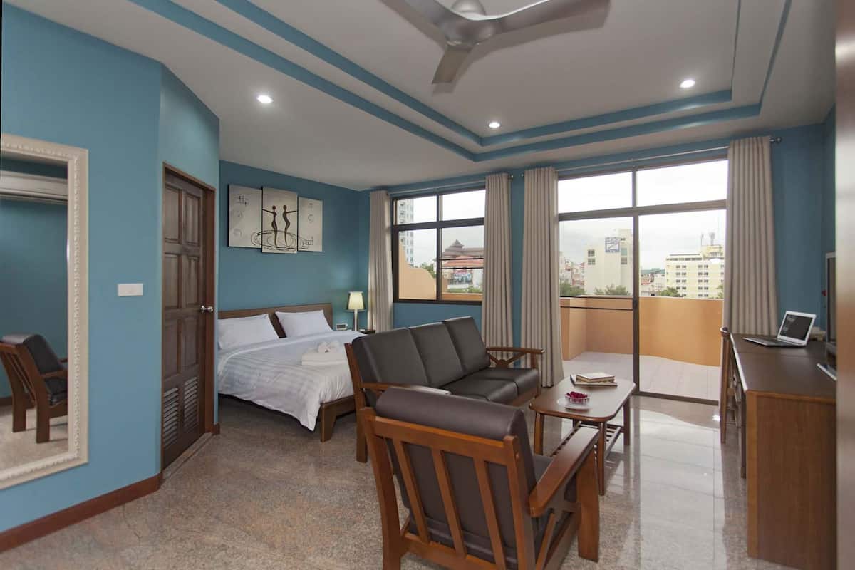 Une chambre d’hôtel comprenant un lit, un canapé, un bureau et un balcon avec vue sur la ville.