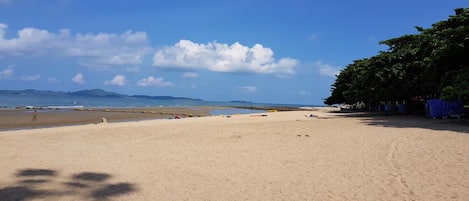 In Strandnähe, weißer Sandstrand, Liegestühle, Sonnenschirme