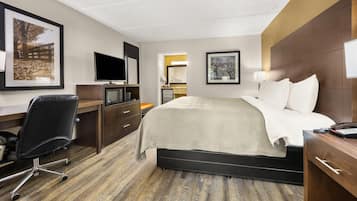Une chambre d’hôtel équipée d’un lit, d’un bureau, d’une chaise, d’une télévision et d’œuvres d’art.