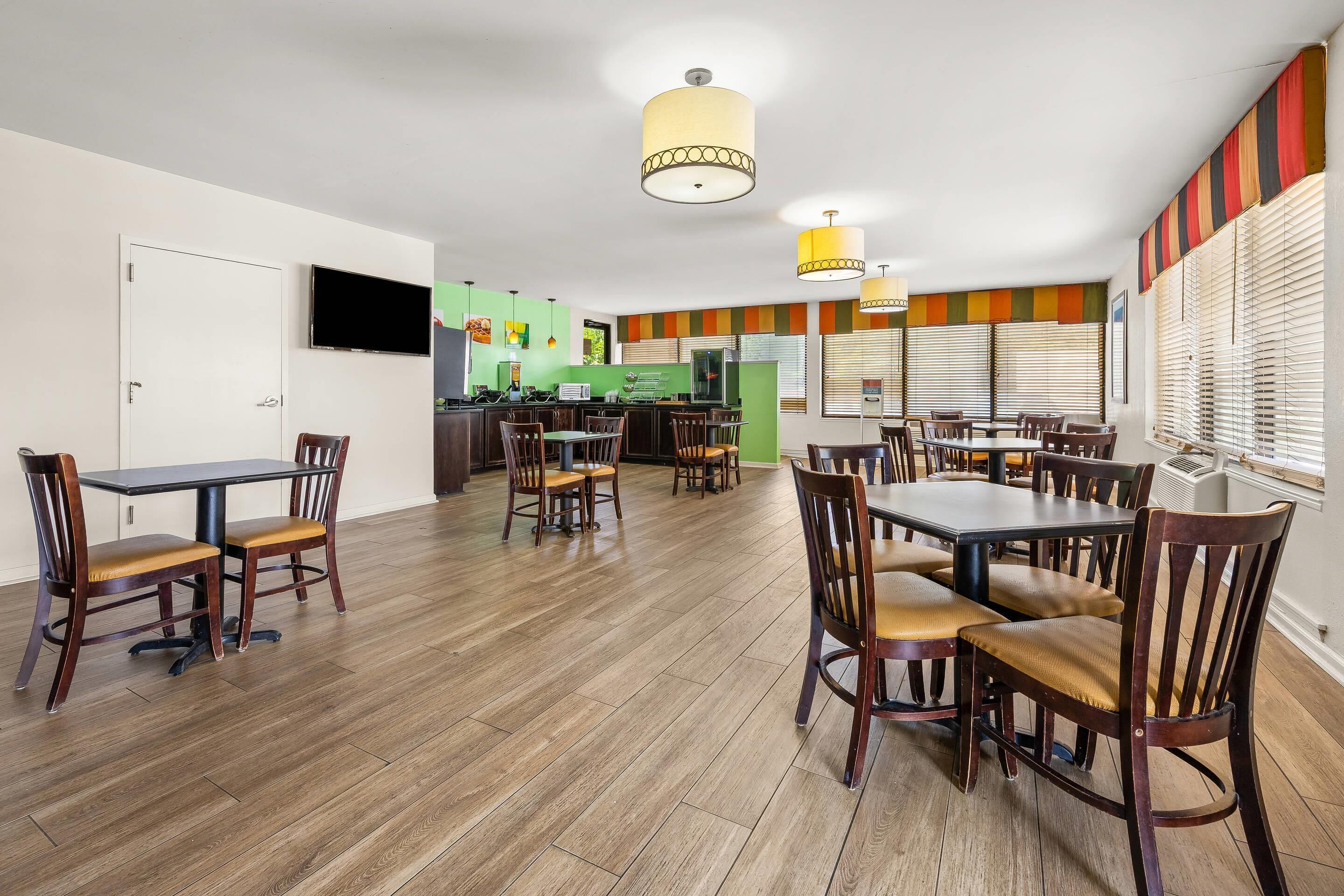 A dining area with wooden flooring, tables, and chairs.