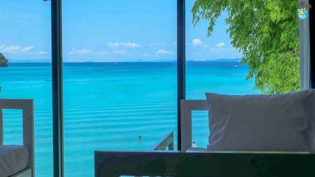 A room with a large window offering a view of the turquoise sea and distant islands. - Ibiza House Phi Phi  (Ko Phi Phi)