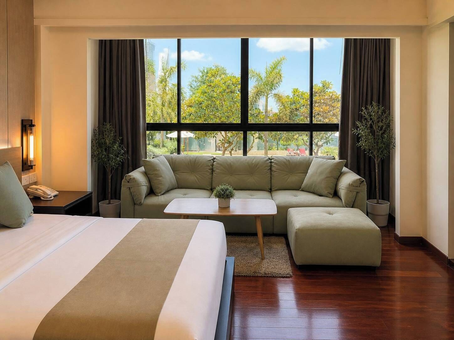 Une chambre d’hôtel avec un grand lit, un canapé, une table basse et une vue sur des palmiers et des immeubles.